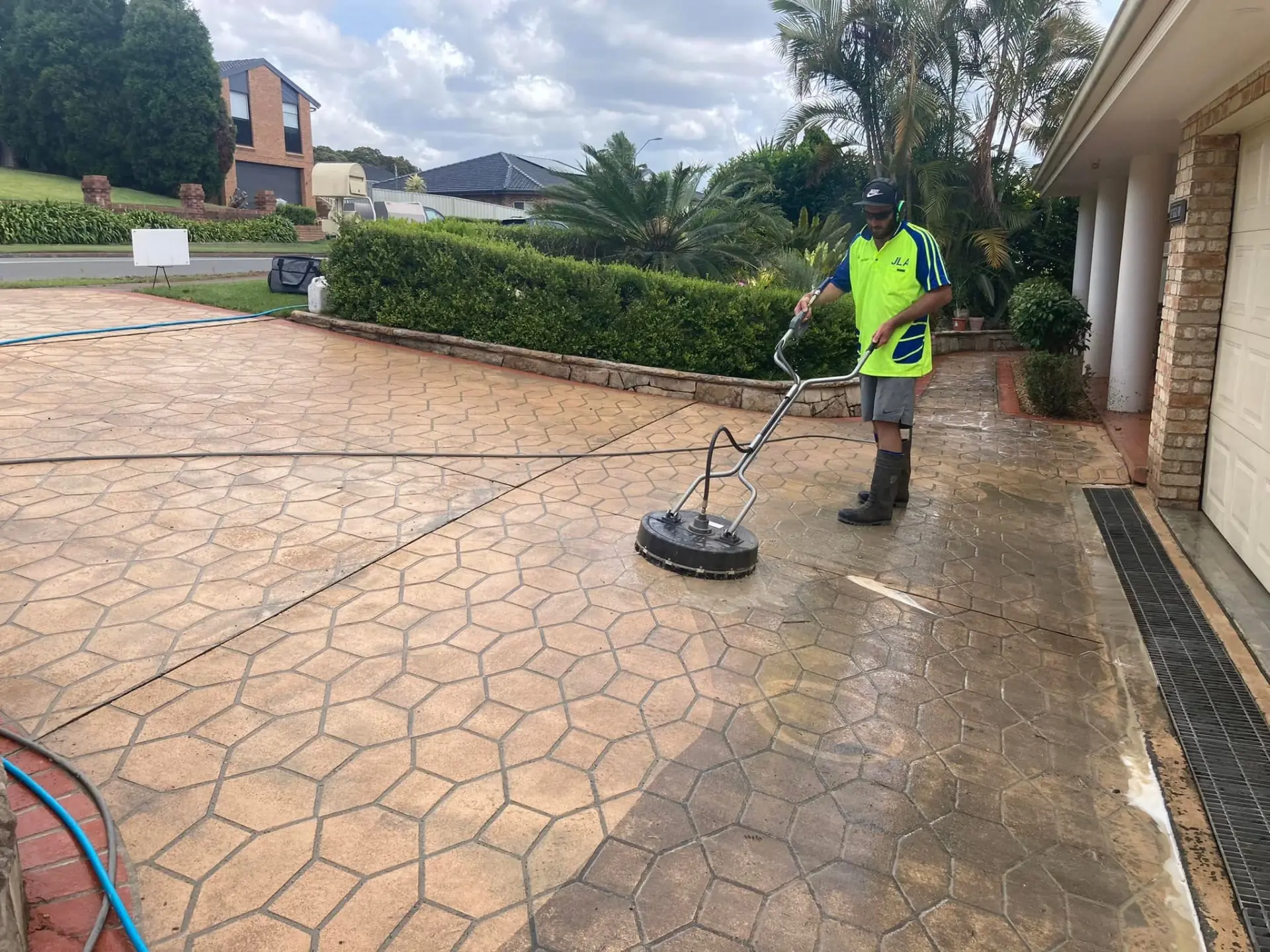 JLA pressure cleaning technician cleaning a stamped concrete driveway at a Lake Macquarie home