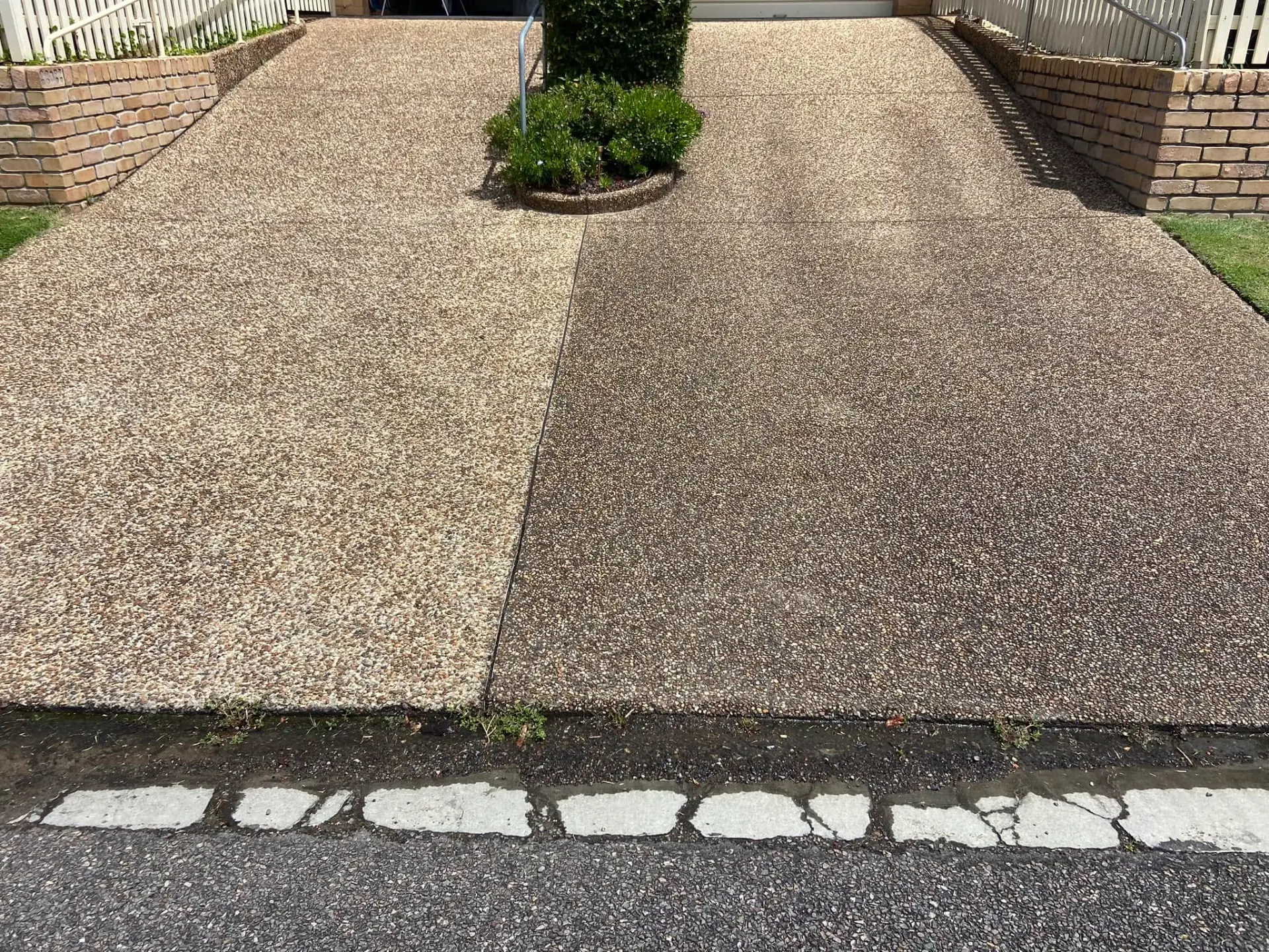 Exposed aggregate driveway half cleaned, showing the difference after pressure washing