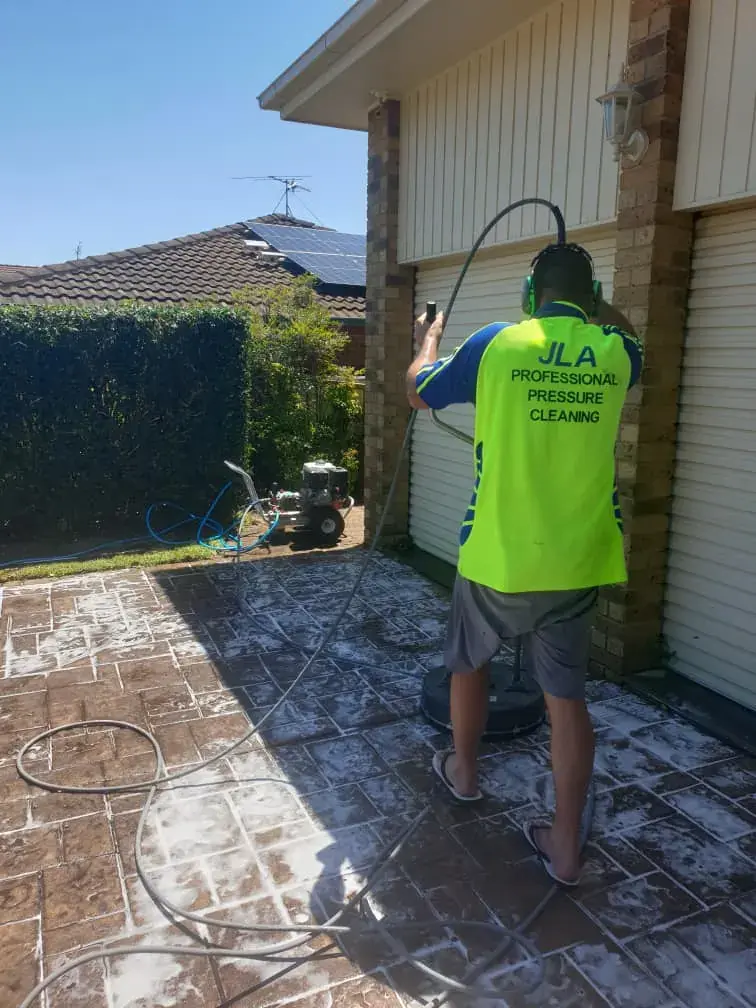 Technician pressure washing a residential driveway