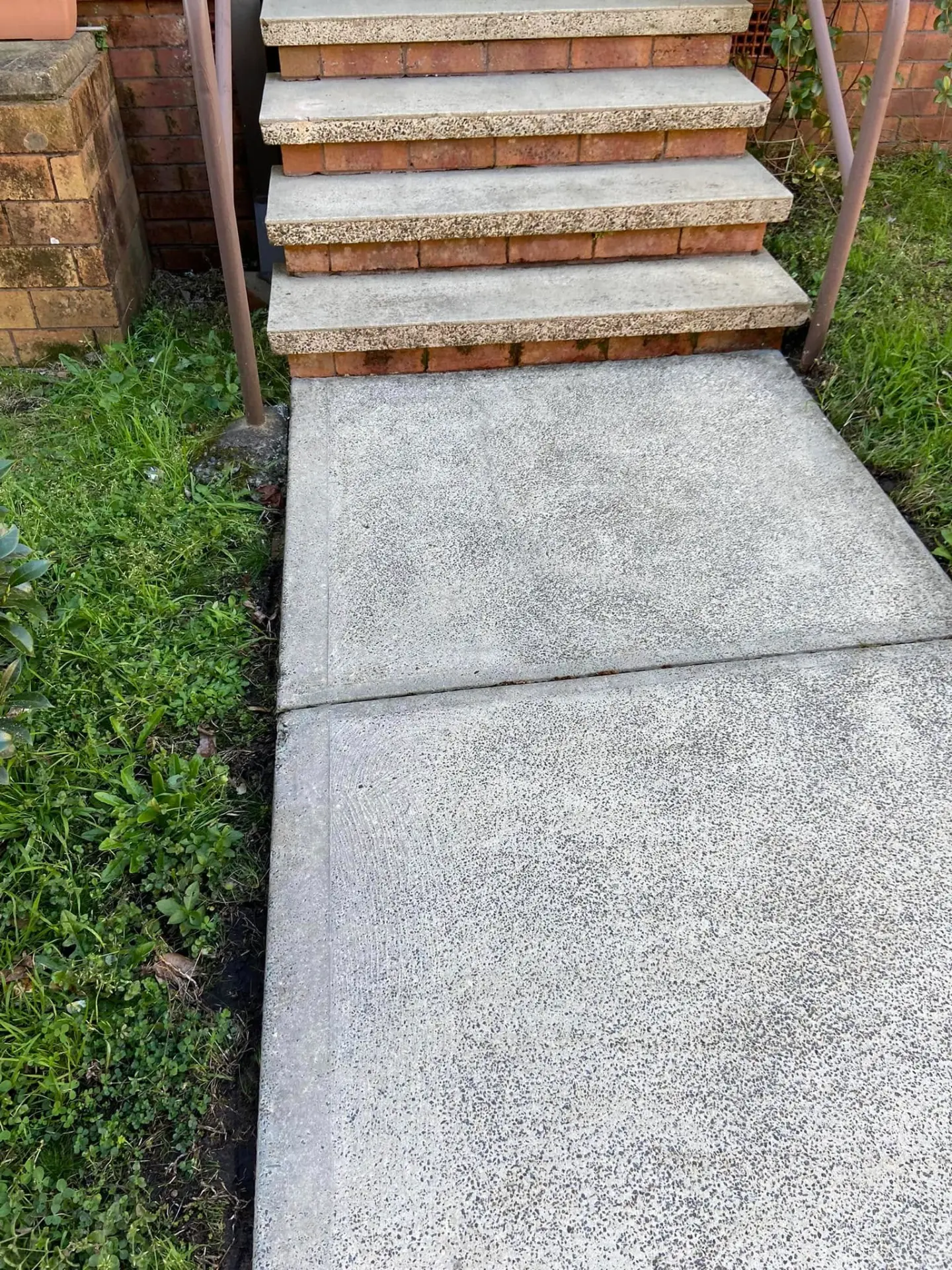 The same outdoor stairs after pressure cleaning, treads restored to clean bare surface